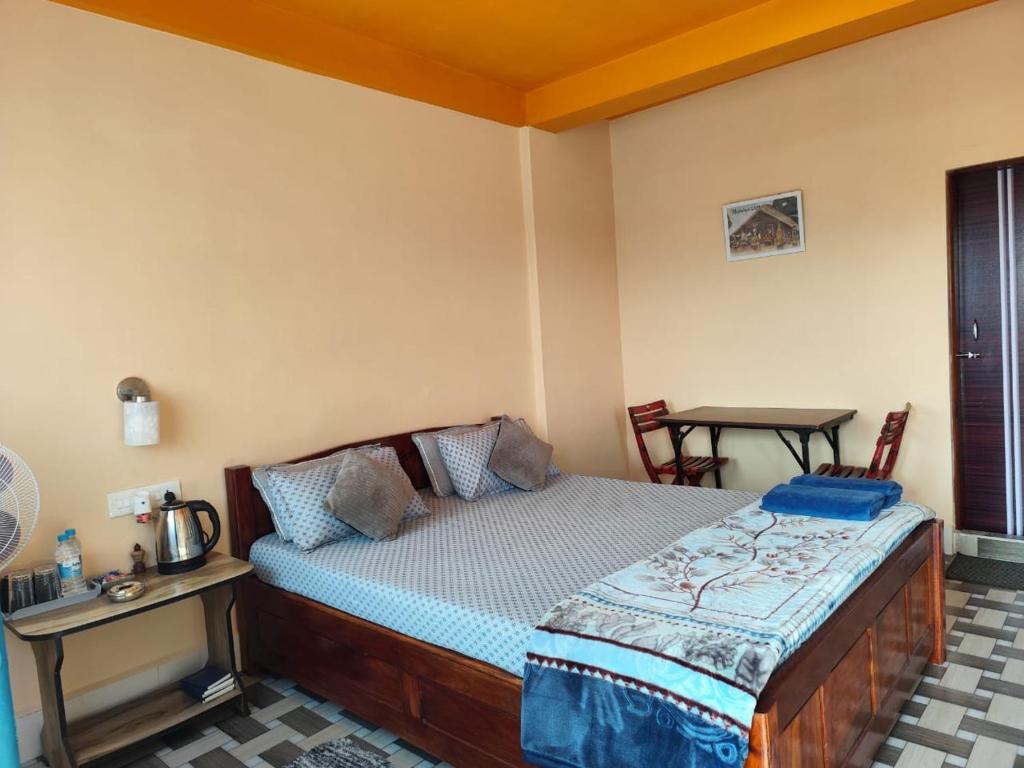 um quarto com uma cama, uma mesa e cadeiras em Arara ibt homestay em Cherrapunji