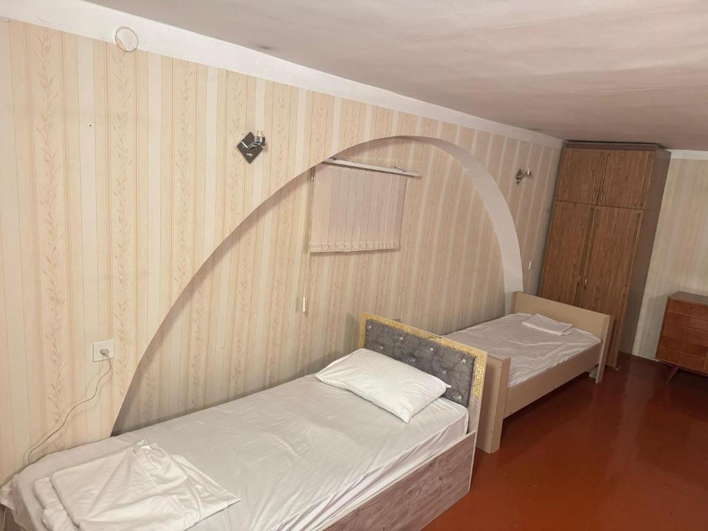 Una pequeña habitación con dos camas y un espejo. en Freestyle Hostel Baku, en Baku
