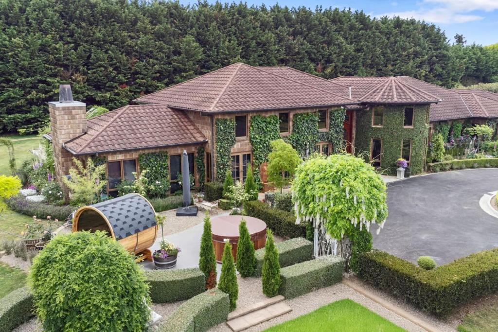 an aerial view of a house with a garden at Le Chateau Moderne - Cedar Barrel Sauna & Spa in Tamahere