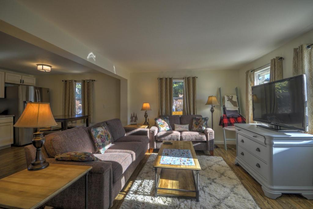a living room with a couch and a tv at Daybreak Haven Red Lodge in Red Lodge