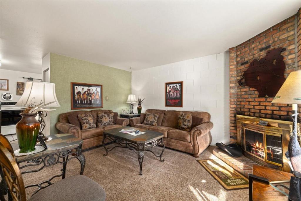a living room with couches and a brick fireplace at The Bears Den in Red Lodge