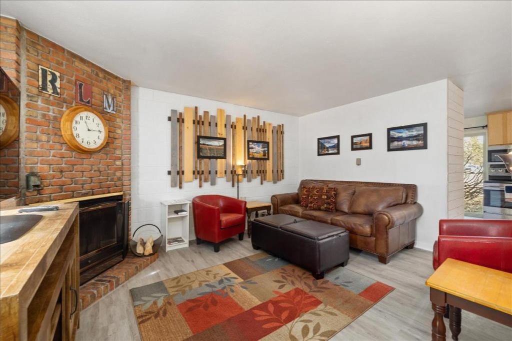 a living room with a couch and a clock on the wall at Winchester Way Red Lodge in Red Lodge