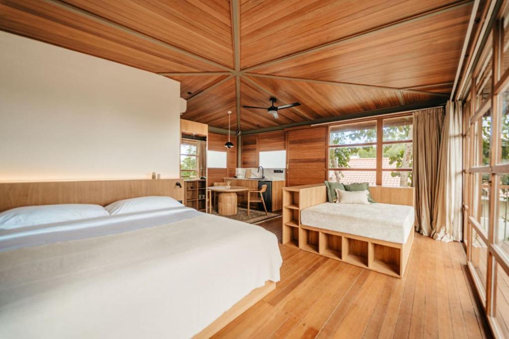 ein Schlafzimmer mit einem großen Bett und einem Schreibtisch in der Unterkunft Villa Beruang in Uluwatu