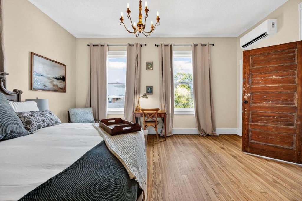 ein Schlafzimmer mit einem großen Bett und einem Kronleuchter in der Unterkunft Charming Loft in Prime Location with Free Parking in Macon