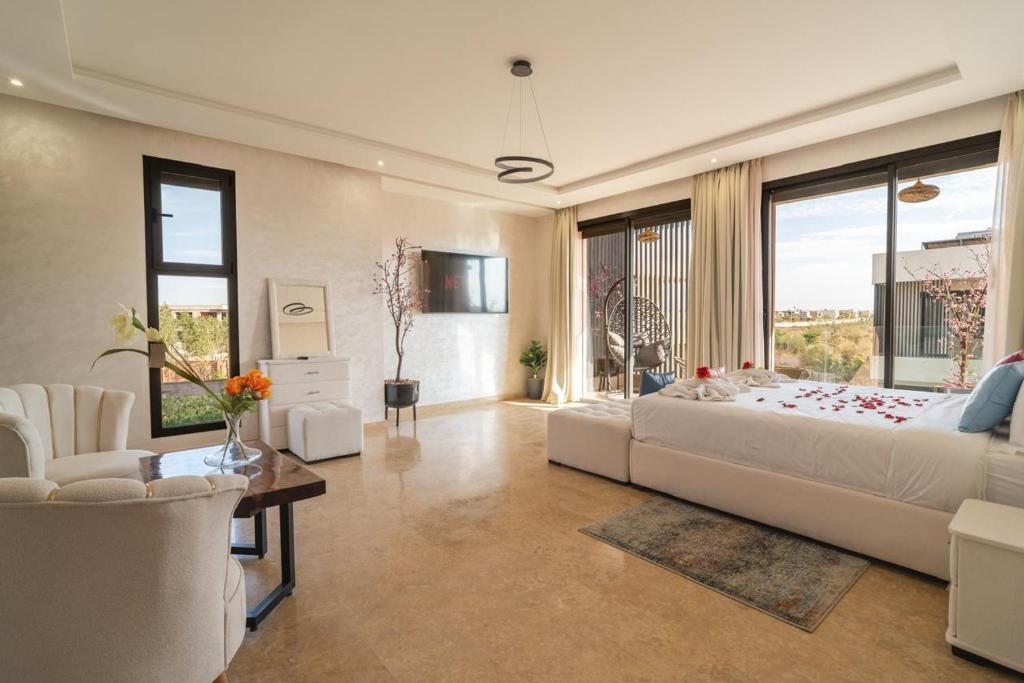 ein Schlafzimmer mit einem großen Bett und einem großen Fenster in der Unterkunft Luxury Villa Hammam Piscine chauffeé sans Vis Avis in El Harkat