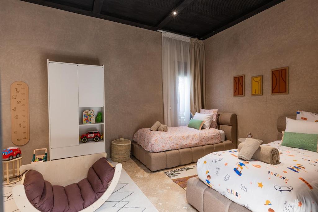 un dormitorio con dos camas y un sofá en Villa Riad Private heated Pool with breakfast, en Marrakech
