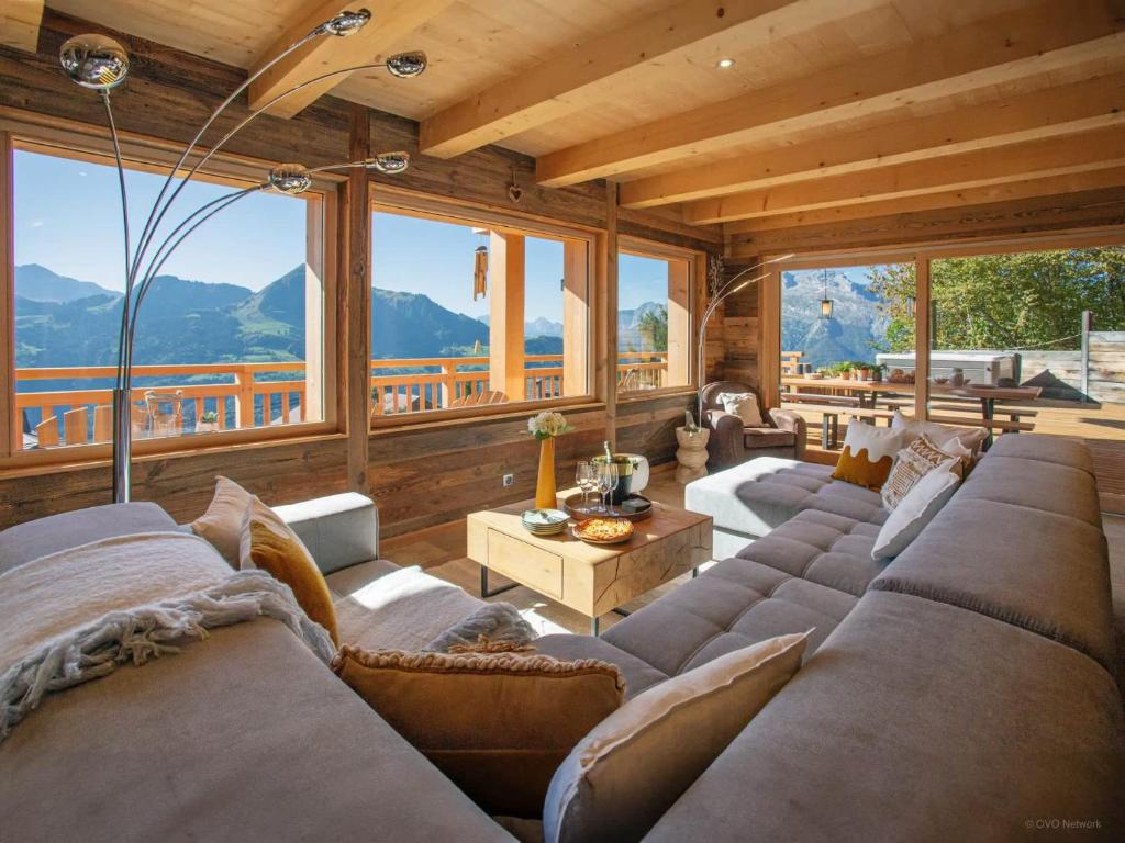 Chalet Serbijanka Alpine Retreat with Hammam Sauna and Jacuzzi for 14 Gueststs في مانيجود: غرفة معيشة مع كنب وطاولات ونوافذ