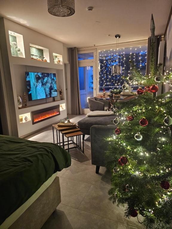 un árbol de Navidad en una sala de estar con chimenea en Harz High End Fewo Nicholas 4 Sterne DTV, en Goslar