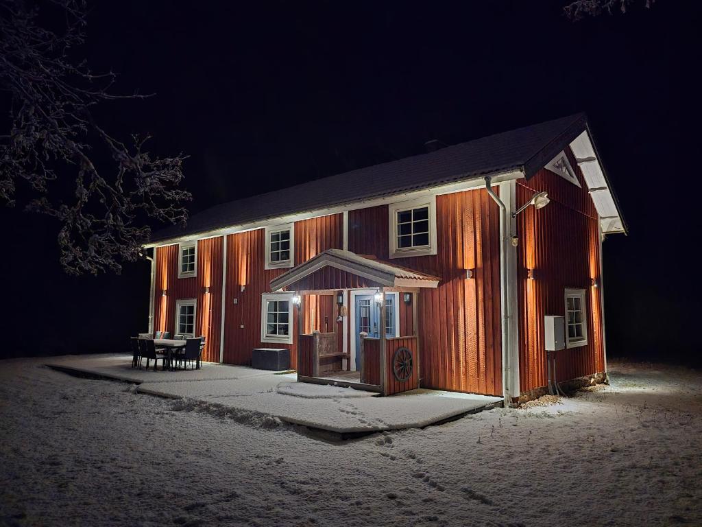 a barn at night with a bench in front of it at Kringelgården in Stamsmåla