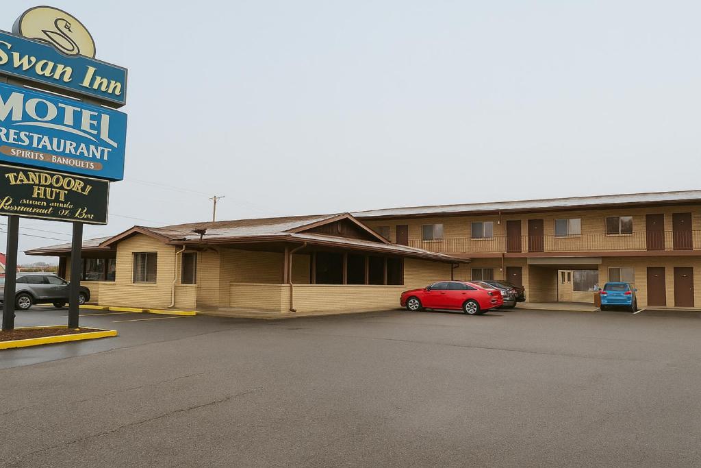 ein Motel mit einem roten Auto, das auf einem Parkplatz steht in der Unterkunft Canton Inn By OYO in Canton