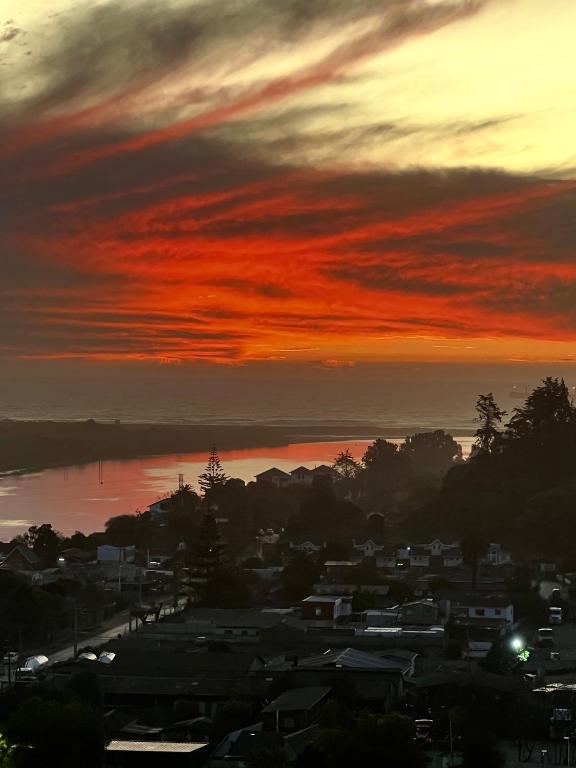 a sunset over a city with houses and a body of water at Beautiful Portal Santo Domingo Apartment in San Antonio