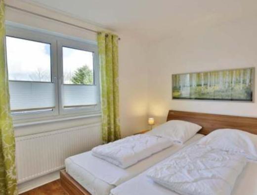 ein Schlafzimmer mit zwei Betten und einem Fenster in der Unterkunft Pension EA'S in Aichach