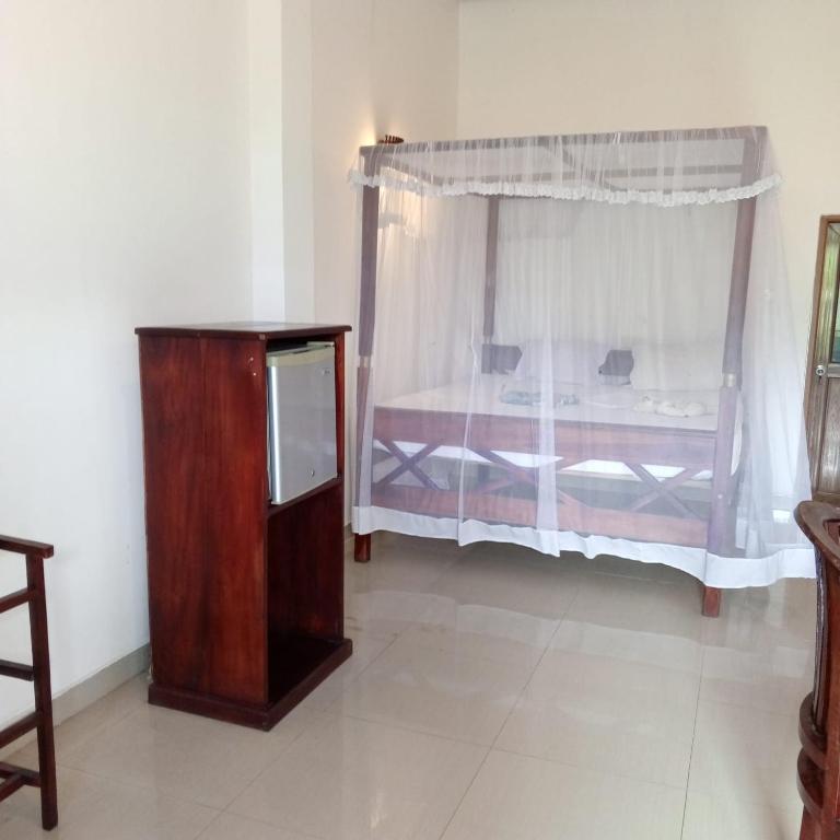 sypialnia z łóżkiem, komodą i oknem w obiekcie Villa Tropi Lanka w mieście Unawatuna