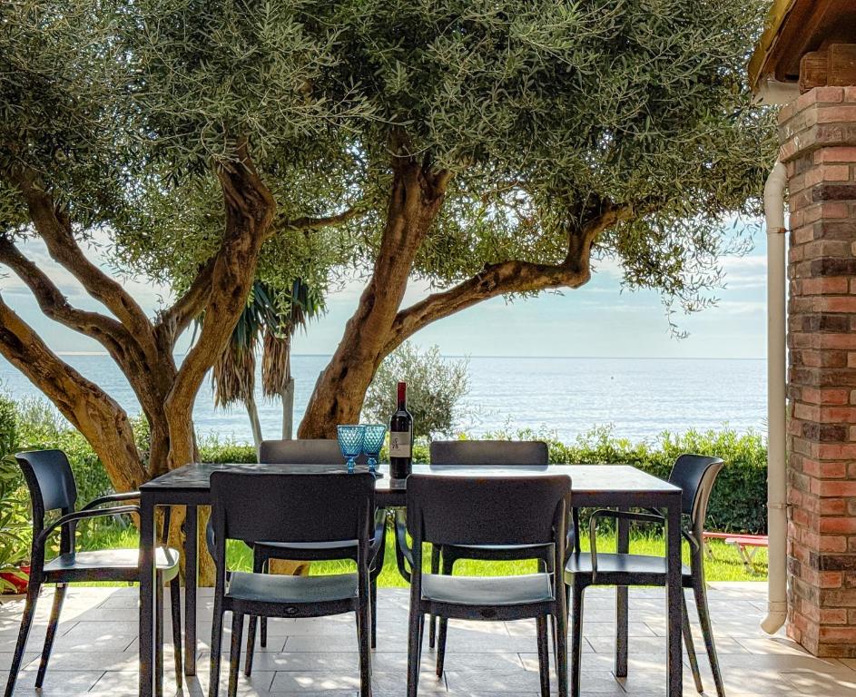 a table with chairs and a bottle of wine at Antonio 50 - Blue Glyfada Private Homes in Glyfada