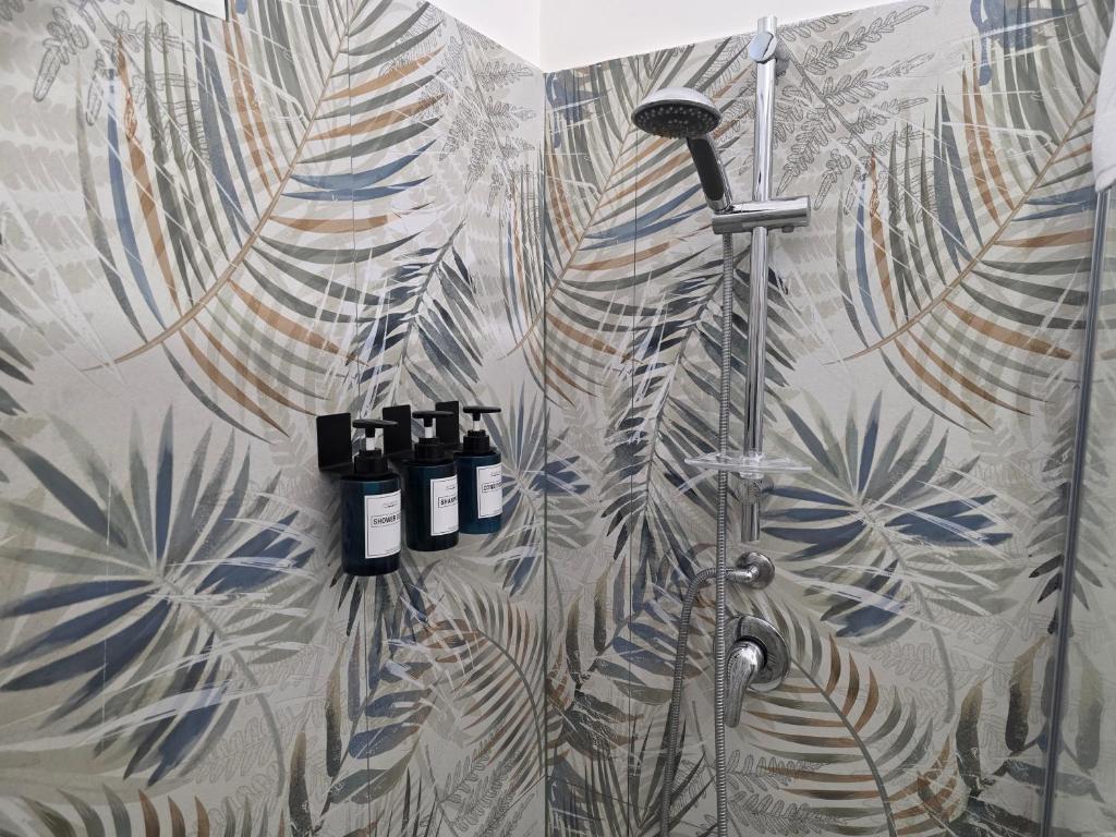 菲乌米奇诺Casa Amare Aeroporto Fiumicino的带玻璃门的淋浴间，配备 aiger