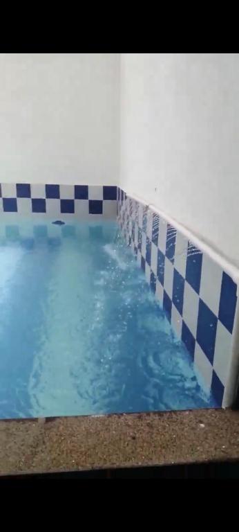 a swimming pool with blue and white tiles on it at Mónaco 1 piso in Carmen de Apicalá