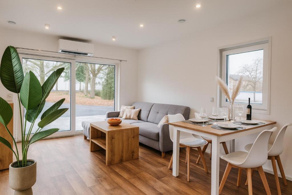 un soggiorno con un divano e un tavolo di Tiny House - Gemütlich, ruhig, privat - mit Parkplatz und Terrasse a Lichtenau