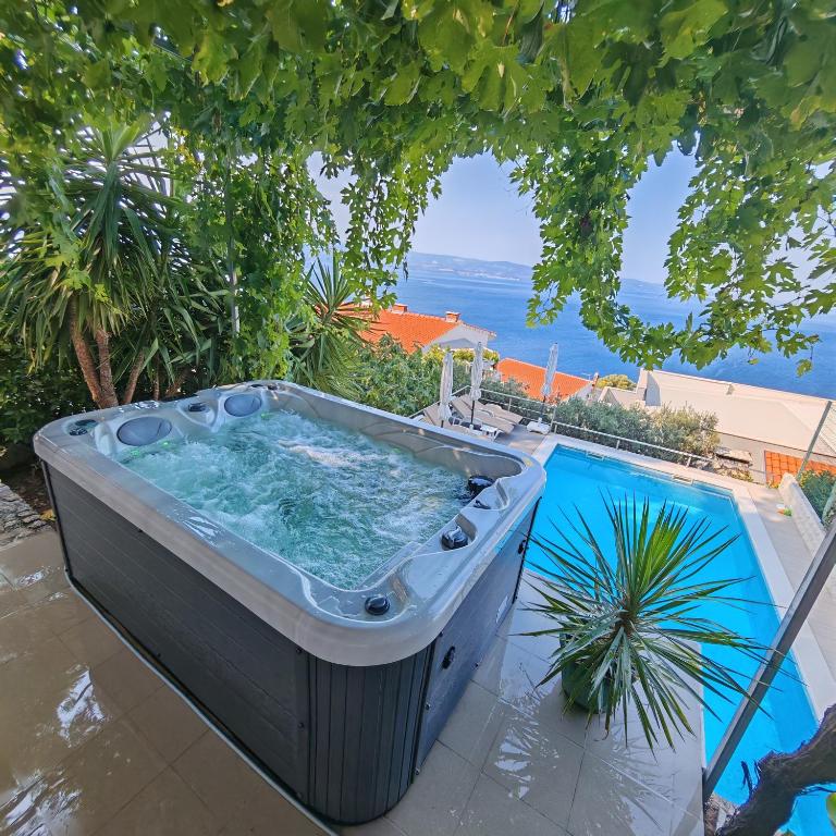 a hot tub on a patio with a view of the ocean at Villa Zorka in Omiš
