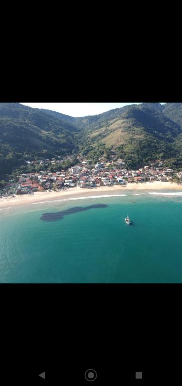 a view of a beach with a boat in the water at Recanto Jane e Daniel in Angra dos Reis