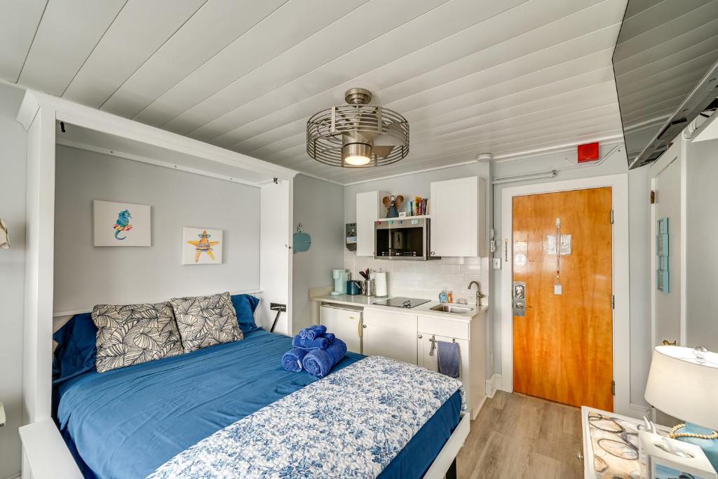 a bedroom with a blue bed and a kitchen at Walk to Beach and Music Pier! Condo in Ocean City in Ocean City