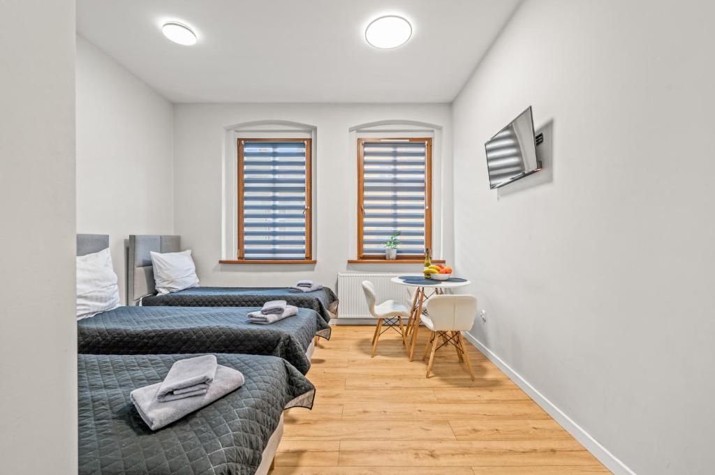 une chambre avec deux lits et une table dans l'établissement Central Platinum Apartments 4, à Rybnik