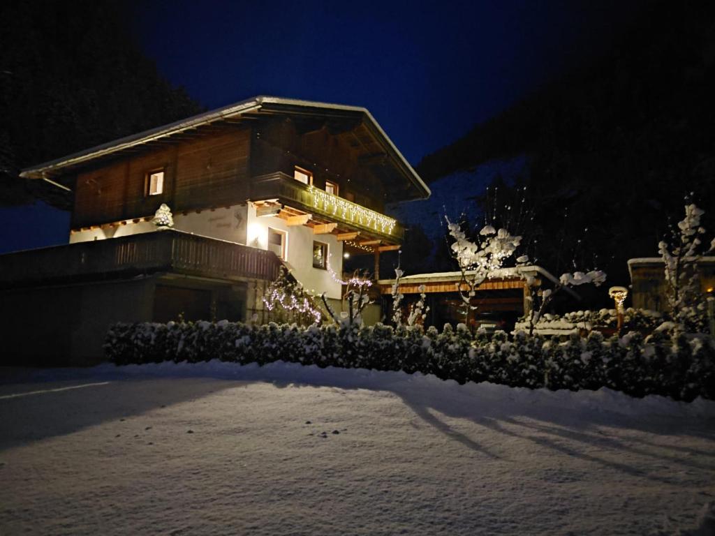 uma casa na neve à noite em Apartment Wandegg im Bergsteigerdorf Ginzling Mayrhofen em Mayrhofen