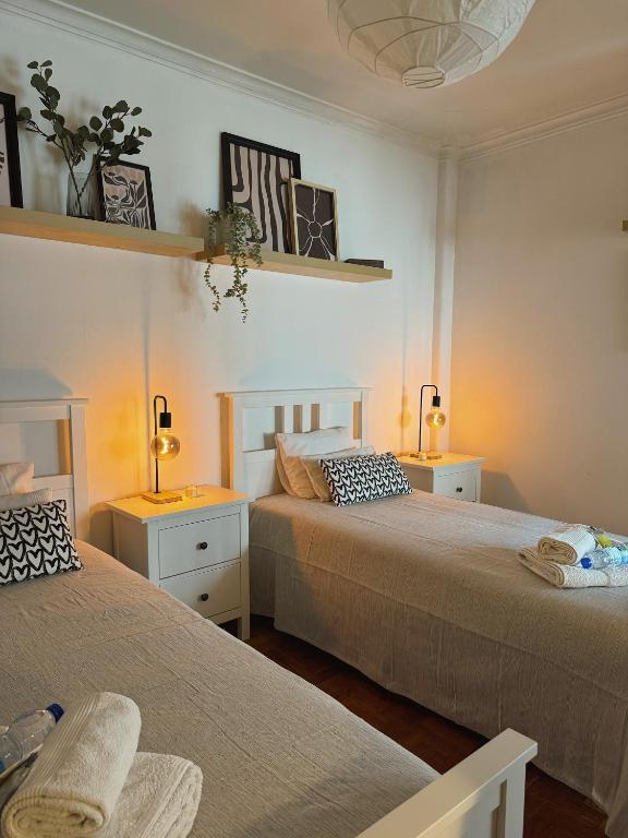 a bedroom with two beds and two lamps and two tables at Cantinho da Avó Mifá in Lisbon