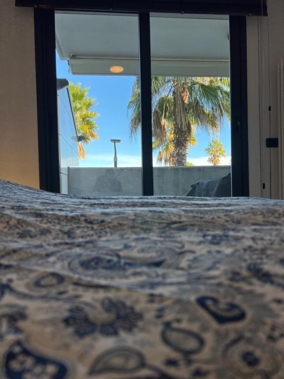 a view of a cross through the window of a room at Palm Grove House con terrazzo e box privato in Loano