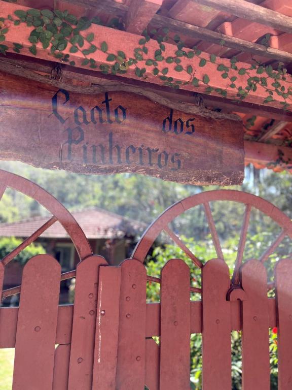 a wooden fence with a sign that reads garden digsinators at Chácara Canto Dos Pinheiros in Vargem Grande Paulista