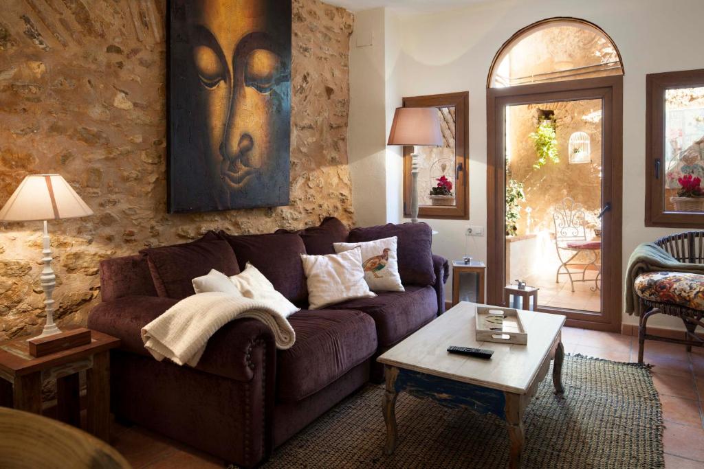 sala de estar con sofá púrpura y mesa en Casa Rural Mirador, en Bocairent