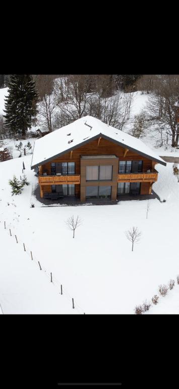 Les FourgsBoutique Hôtel - Notre Chalet的一座大木屋,地面上积雪