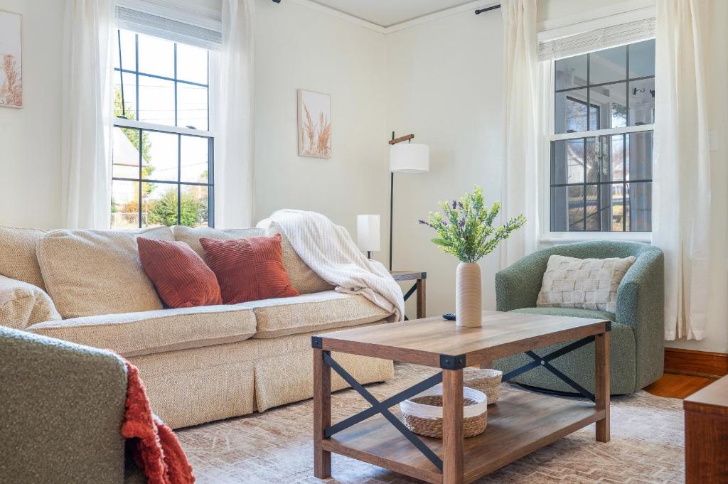 een woonkamer met een bank en een tafel bij Sage & Stone Cottage in Lynchburg