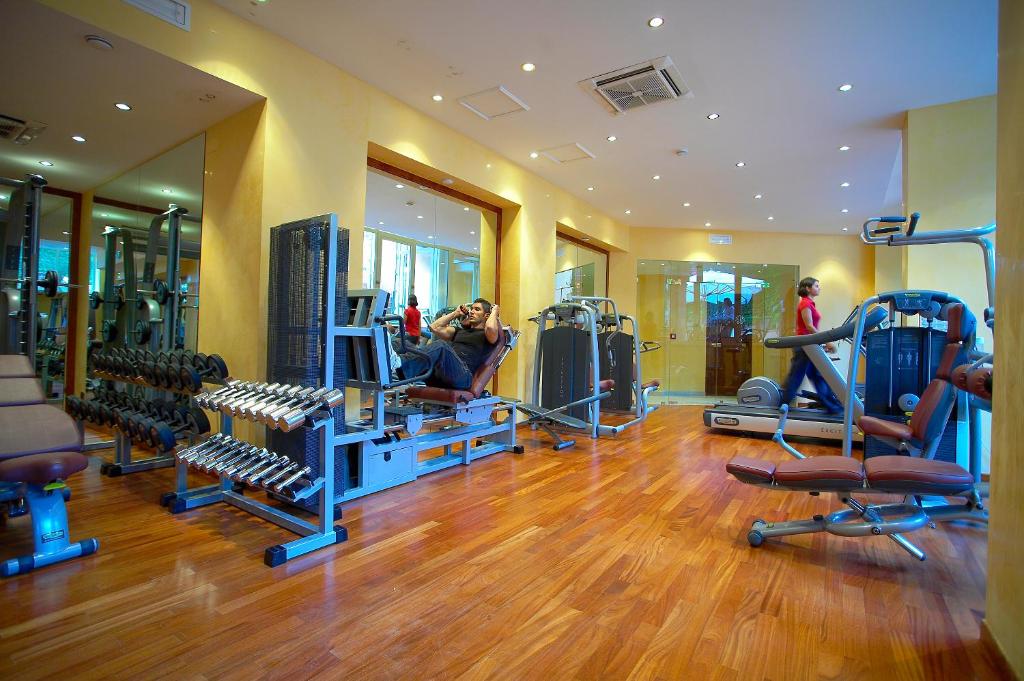 a gym with several treadmills and people in it at Hotel Caparena in Taormina