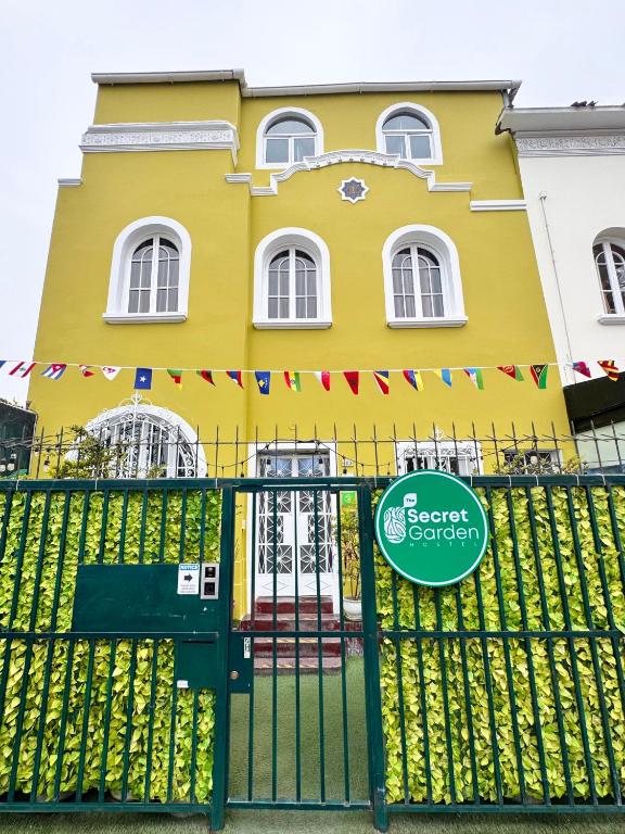 a yellow house with a gate in front of it at The Secret Garden Hostel in Lima