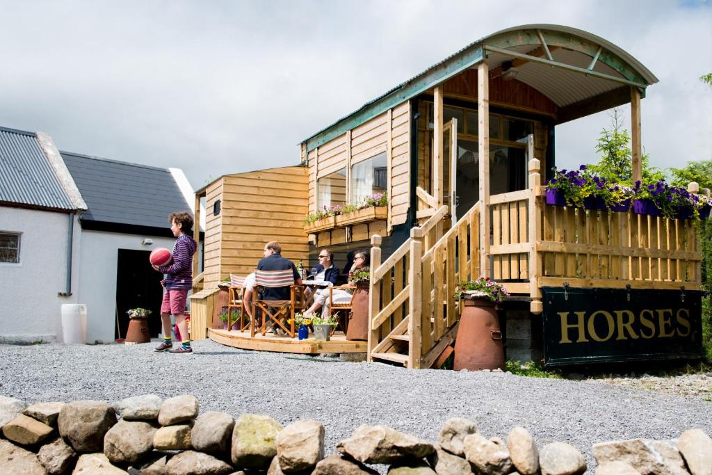a woman standing in front of a tiny house at Burren Glamping in Kilfenora