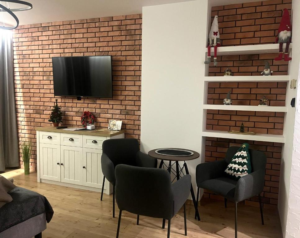 a living room with a tv on a brick wall at Apartament 8 in Toruń