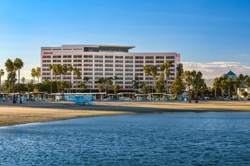 a building on the beach next to a body of water at Marina del Rey Marriott in Los Angeles