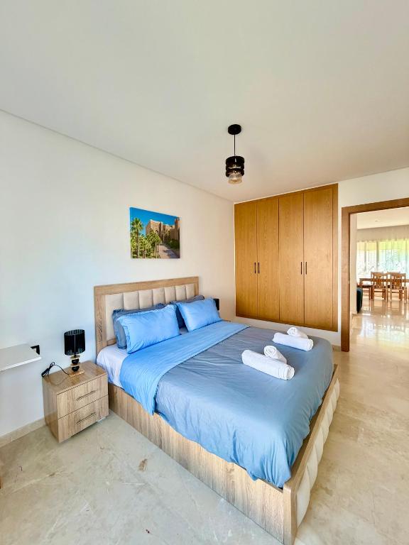 a bedroom with a large bed with blue sheets at Charmante maison de vacances proche de la plage à quelques minutes de Rabat in Temara