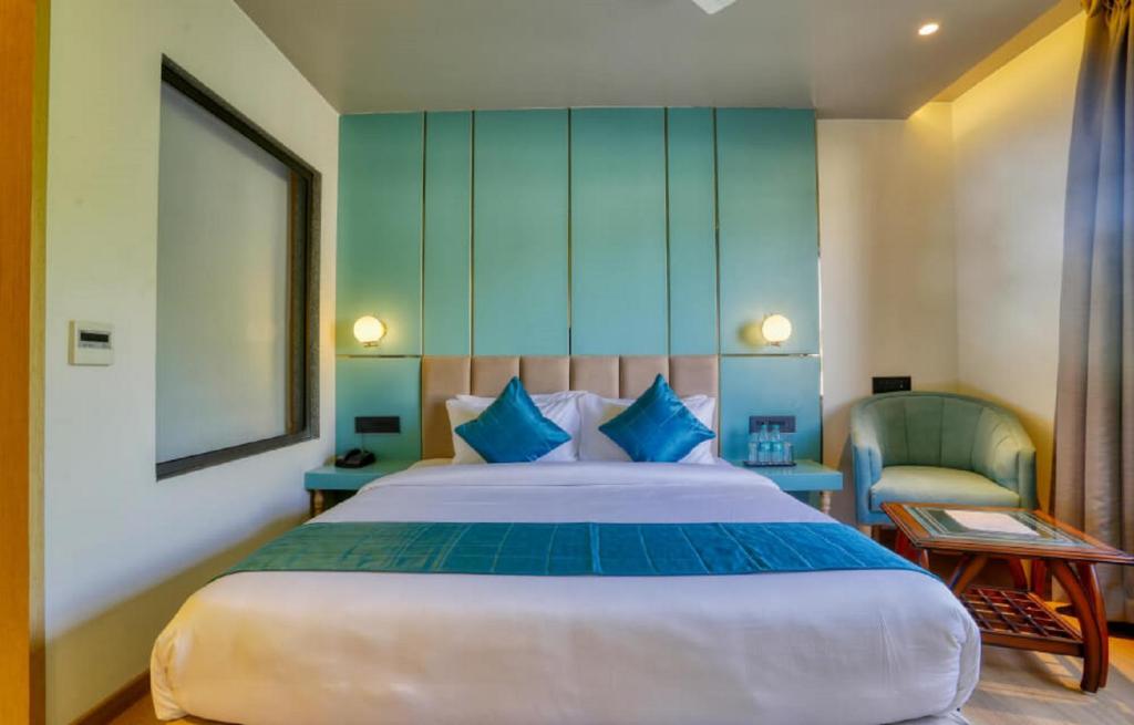 Un dormitorio con una cama grande y una silla en Hotel TEO SUITES International Airport, en Nueva Delhi