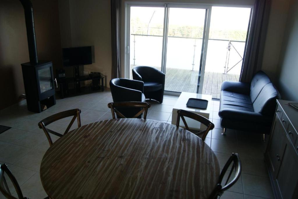 un soggiorno con tavolo, sedie e divano di Villa Residence Kersaliou a Roscoff