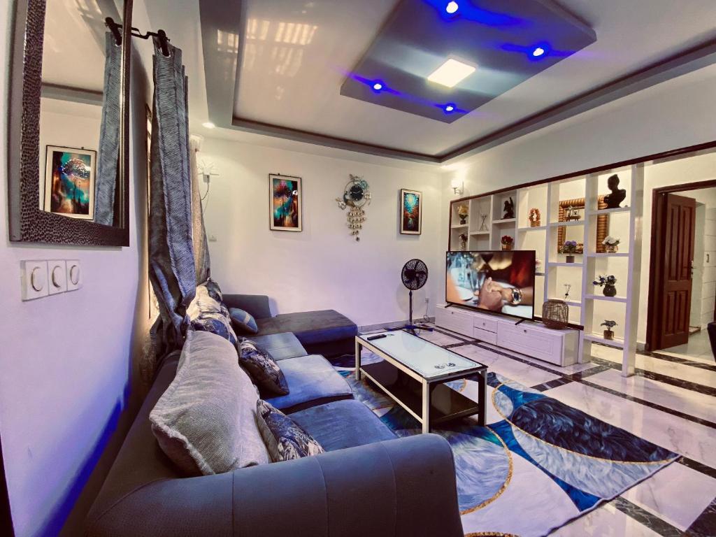 a living room with a couch and a tv at Résidence de la Paix in Yaoundé