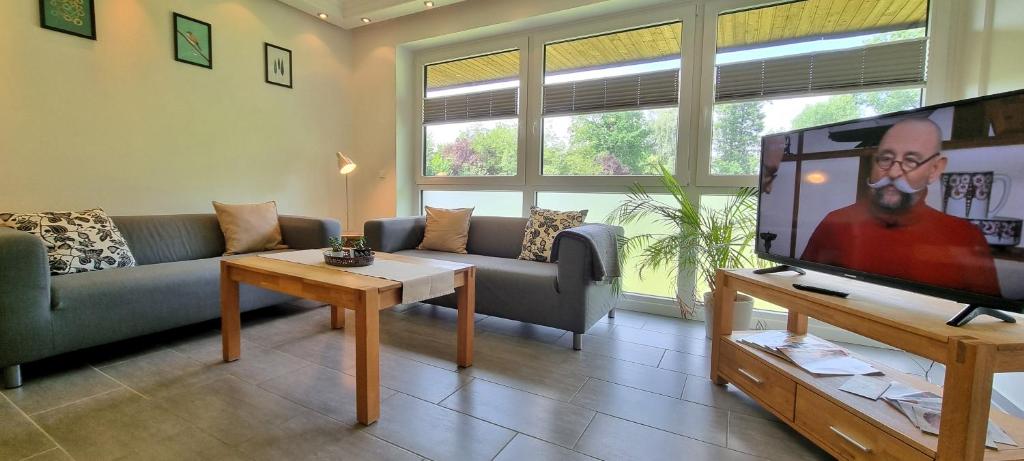 a living room with a couch and a flat screen tv at Ferienwohnung Pulvermühlenteich in Seevetal