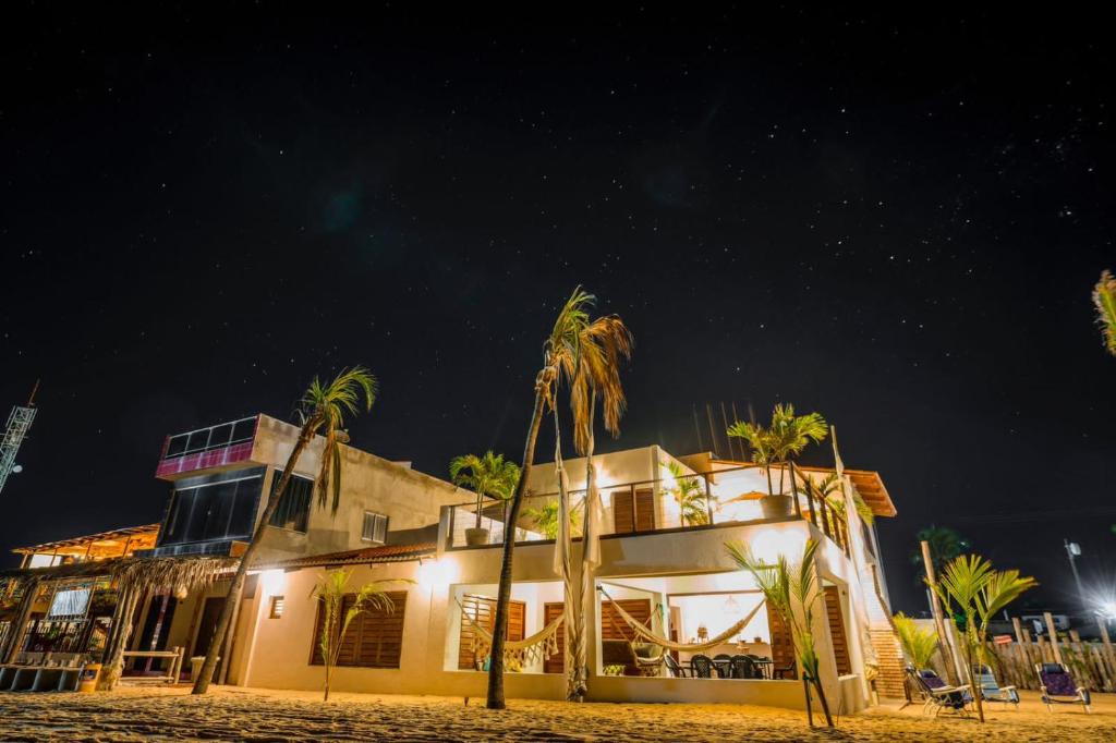a building on the beach at night with palm trees at Casa Galo Pretto in Galinhos