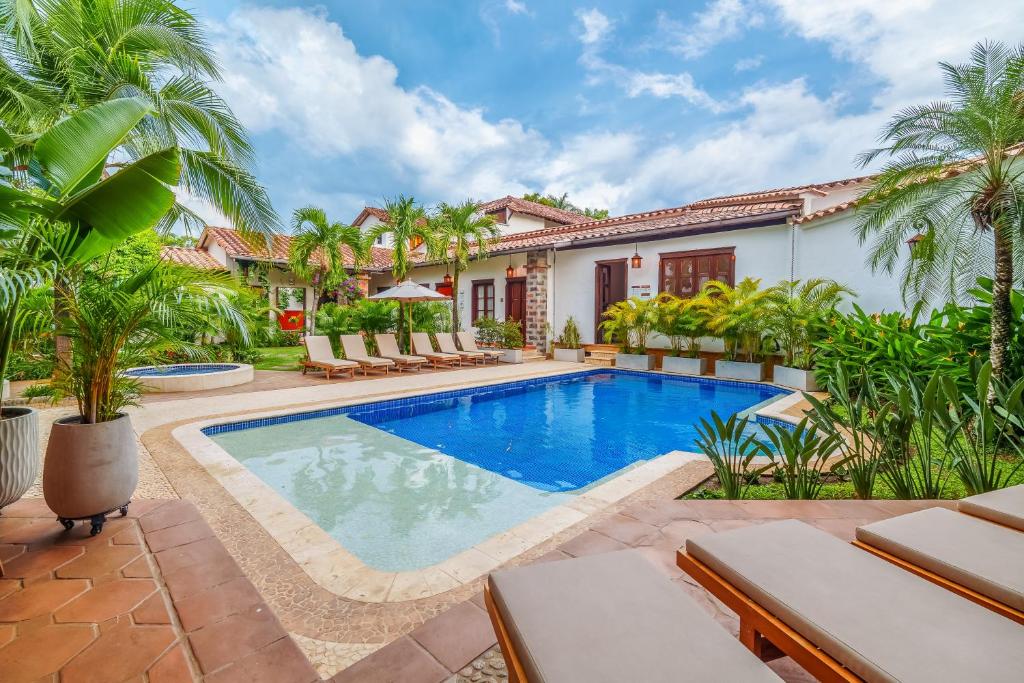 uma piscina em frente a uma casa com palmeiras em Casa Linaje Hotel Boutique by HMC -Cauca Viejo- Mayores de 10 años em Jericó