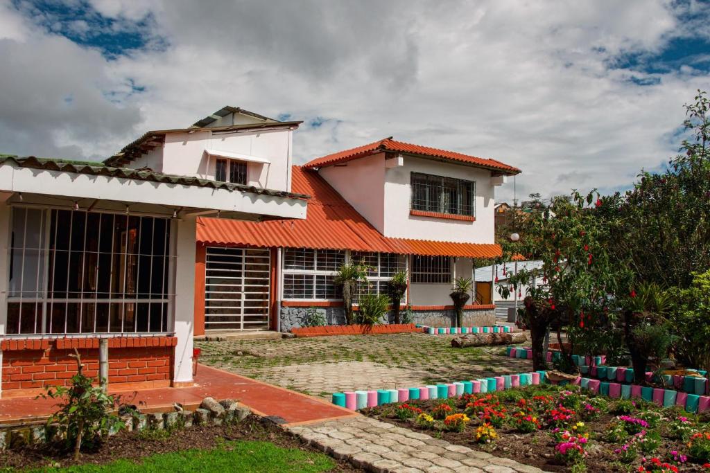 a house with a garden in front of it at Hostal las margaritas in Pasto