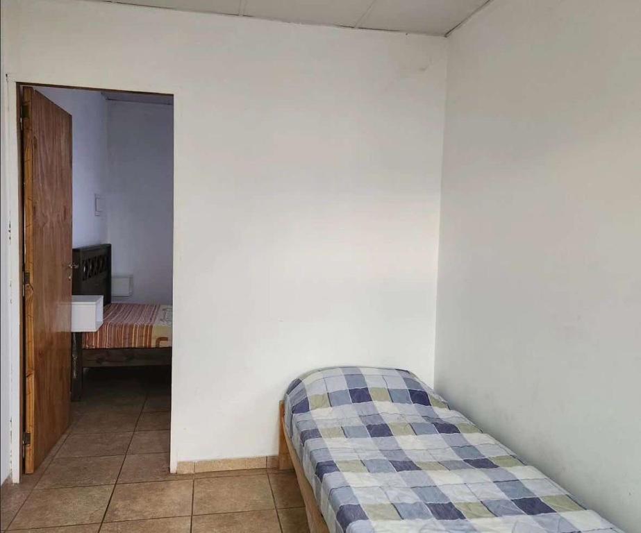 圣拉斐尔Complejo de Cabañas Quintana Cochera Cocina Wifi Smartv Aire Acondicionado的卧室配有白色墙壁上的床铺