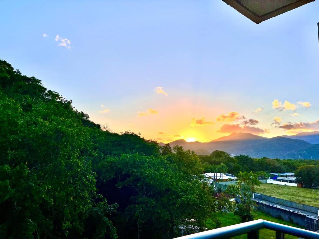 a view of the sunset from a balcony at NOVIDADE! Apartamento Bella Vita Bertioga in Bertioga