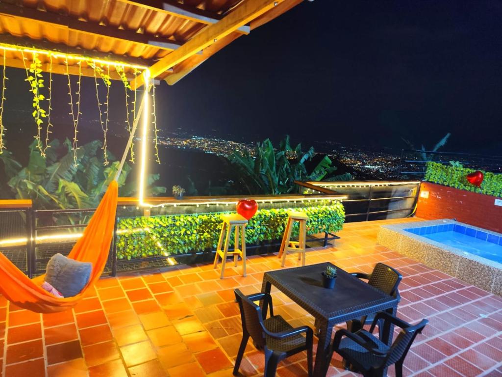 Un patio con hamaca y vista a la ciudad. en Glampin y Cabañas MAGISTRAL VILLA EL EDEN, en Cali