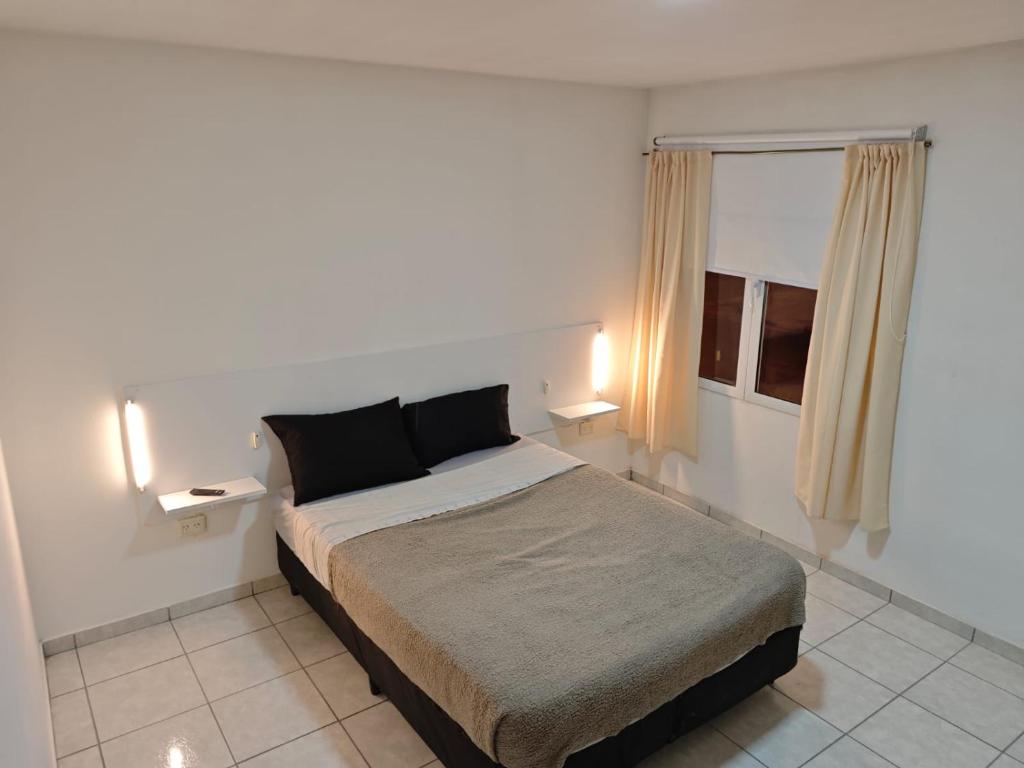 Un dormitorio con una cama grande en una habitación blanca. en Del Norte, en Playa Unión