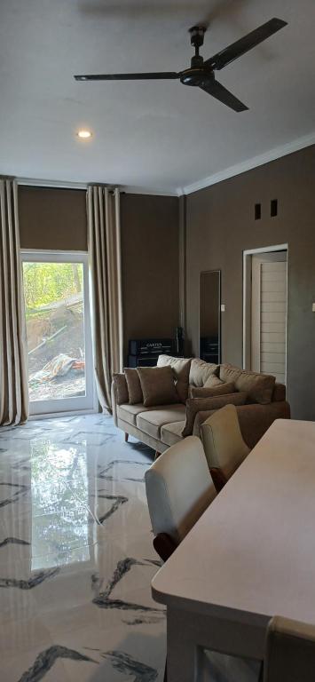 a living room with couches and a ceiling fan at Villa Panorama Amed in Ambat